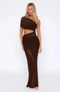 Detail of elegant one-shoulder dark brown ruched maxi dress with waist cutout