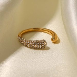 Detailed close-up of a gold-plated open ring with micro-paved white cubic zirconia stones