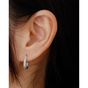 Close-up of a sterling silver hoop earring with micro-pave cubic zirconia on a model