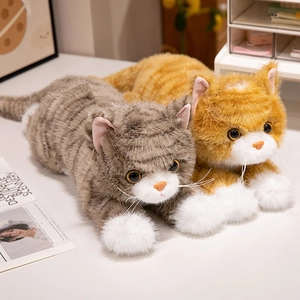 Realistic orange and grey tabby cat plush dolls in a cozy home setting on white surface
