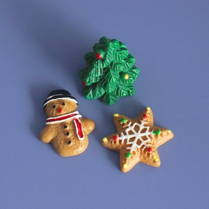 Detail view of miniature resin Christmas tree, gingerbread man and star cookie charms