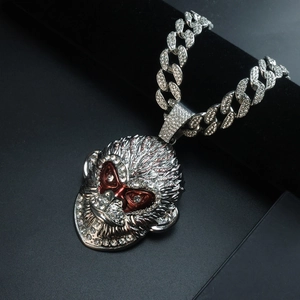 Detailed close-up of a silver monkey pendant with clear crystals and red gem eyes