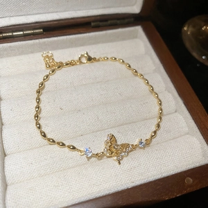 Close-up of 18k gold plated bracelet with zircon butterfly and olive-shaped chain links