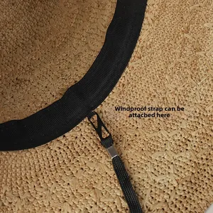 Macro view of detachable windproof rope point and black sweatband on woven raffia sun hat