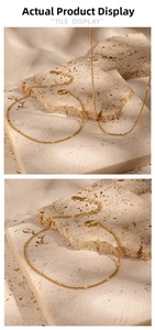Detail of S925 sterling silver gold-plated chain with lobster clasp on stone background