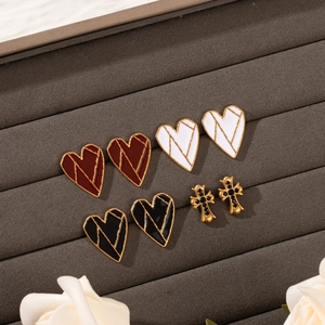 Set of four 18k gold plated stainless steel heart and cross stud earrings on display