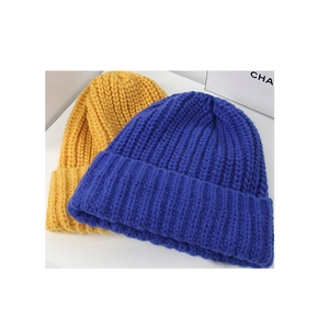 Detailed close-up showing thick ribbed knit texture of yellow and blue beanies