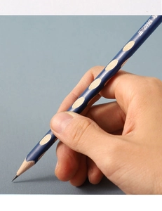 Close-up of student hand holding blue ergonomic wooden pencil with finger positioning holes