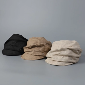 Three cotton linen newsboy caps in black, brown, and beige with metal button detail