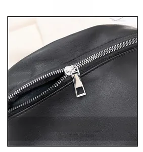 Close-up of smooth silver metal zipper on premium black leather crossbody bag texture