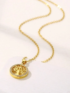 Detailed close-up of golden Tree of Life pendant with white crystals on a stone display