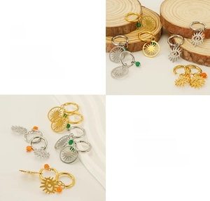 Détail de boucles d'oreilles soleil et œil porte-bonheur en finitions or et argent