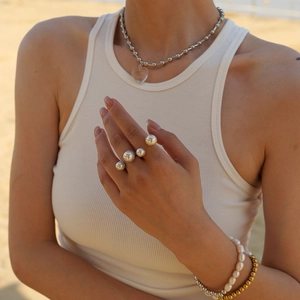 18K gold and silver stainless steel rings with pearls shown on model at beach