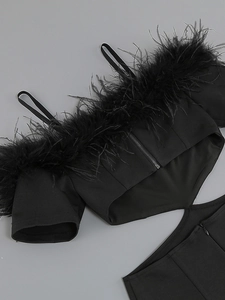 Detail of elegant black off-shoulder dress featuring premium feather trim and slim straps