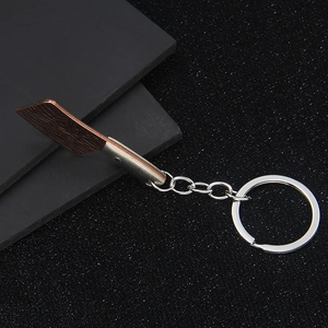 Mini-Metall-Hackmesser-Schlüsselanhänger mit Kupferklinge auf dunklem Hintergrund
