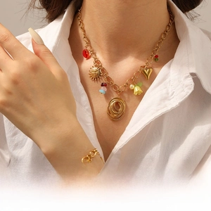 Detailed shot of a gold chunky link jewelry set with sun and lily pendants on a white shirt