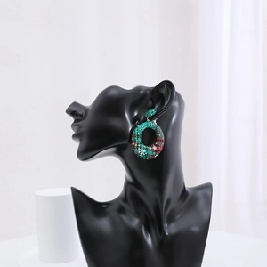 Detailed view of Christmas plaid pattern round earrings displayed on a black model bust