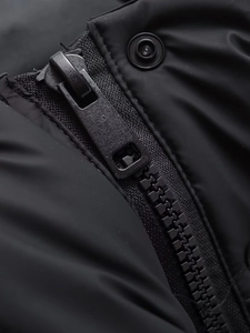 Macro detail of high-quality black zipper and snap button on padded winter jacket