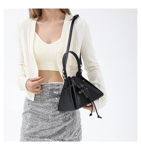 Detail shot of a black punk triangle crossbody bag with silver cross and drawstring
