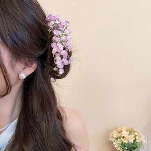 Detail of elegant purple fabric flower hair pin with a large white pearl earring