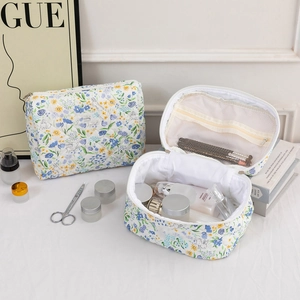 Quilted floral cotton cosmetic bag featuring interior mesh pockets and skincare storage