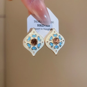 Macro shot of vintage enamel heart earrings with central brown gemstone detail