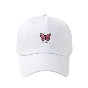White cotton baseball cap with pink butterfly embroidery and be the change text