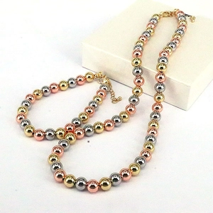 Three-tone gold silver and rose gold beaded bracelet set with lobster clasp on a gift box