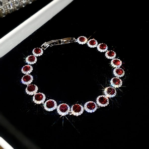 Gros plan du bracelet en zircon avec pierre rouge dans un écrin en velours noir