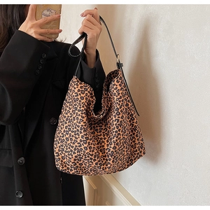 Detailed view of leopard print tote bag with black strap and soft canvas texture