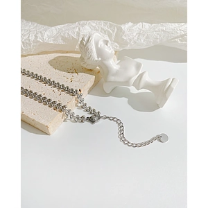Detailed macro shot of a silver wheat-link bracelet with extension chain and round tag