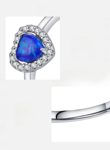 Macro detail of S925 sterling silver ring with triangular blue opal and zircon halo