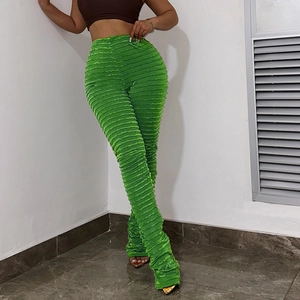 Détail du pantalon vert taille haute plissé avec une texture de tissu à plis empilés