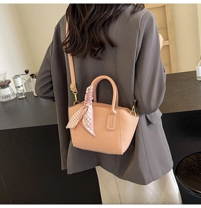 Detail of peach pink lychee grain bucket bag with silk scarf on a model back view