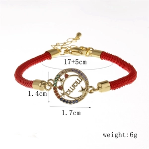 Detail of red woven bracelet featuring a gold MAMA charm with vibrant zircon stones