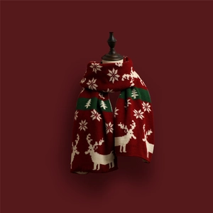 Detail of Christmas knitted scarf with white reindeer and snowflake patterns on red fabric