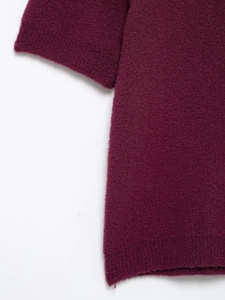 Detail view of burgundy knit cardigan showing high-density fabric and ribbed hem finish