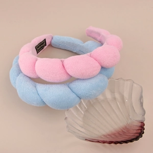 Close-up of pink and light blue plush braided headbands with handmade woven labels