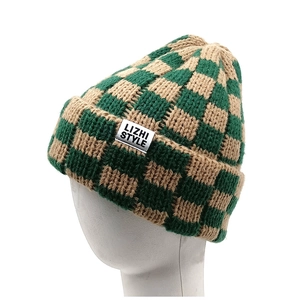Checkerboard knit beanie with green and brown patterns and a woven side label