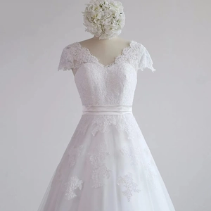 Close-up of V-neck wedding dress with floral lace appliques and white satin ribbon
