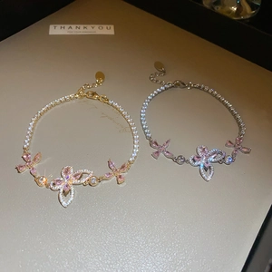 Detail of butterfly bracelets with pink marquise zircon stones and 18K gold plated chains