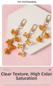 Macro shot of realistic PVC popcorn pendants with gold lobster clasps on pink background