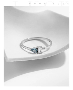 Detail of 925 sterling silver ring featuring pear-cut blue and rectangular clear gems