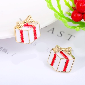 Close-up of gold Christmas gift box earrings with red ribbons and festive glitters