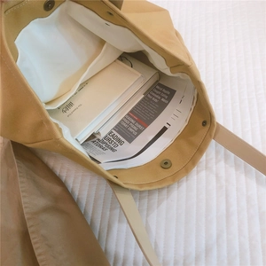Detail view of khaki canvas tote bag featuring interior magnetic closure and inner pocket