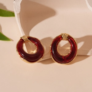 Detailed macro view of retro dark red resin round stud earrings with gold-plated metal borders