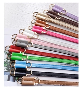 Flat lay of colorful PU leather skinny belts featuring gold metal D-shaped buckles