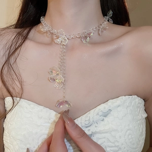 Detail of elegant clear flower beaded Y-necklace worn by a model in a close-up view
