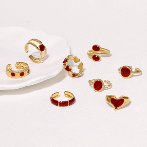 Set of eight gold-finished stainless steel rings with red enamel and heart designs