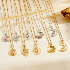 Détail de colliers lune or et argent avec zircon rose sur tissu en soie jaune